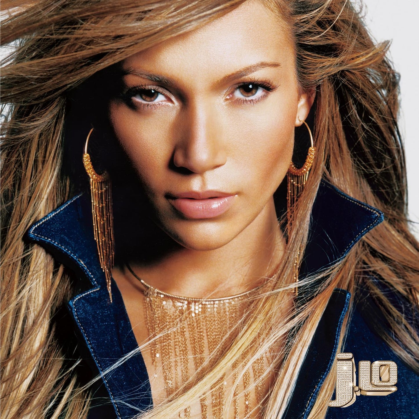 Close-up portrait of Jennifer Lopez with long hair and gold jewelry.