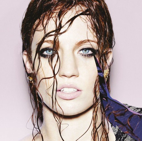 Jess Glynne album cover, wet hair, blue eyes, pale pink background.