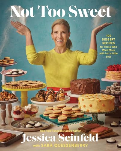 Jessica Seinfeld smiling behind a table filled with various desserts on a blue background.
