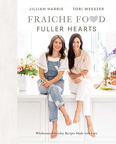 Cookbook cover featuring two women seated on a kitchen counter.