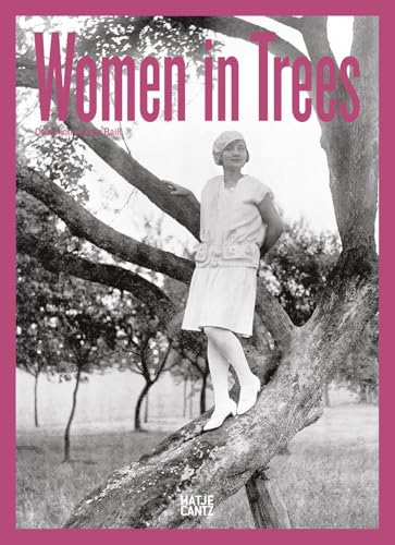 Black and white photo of a woman in a dress, standing in a tree.