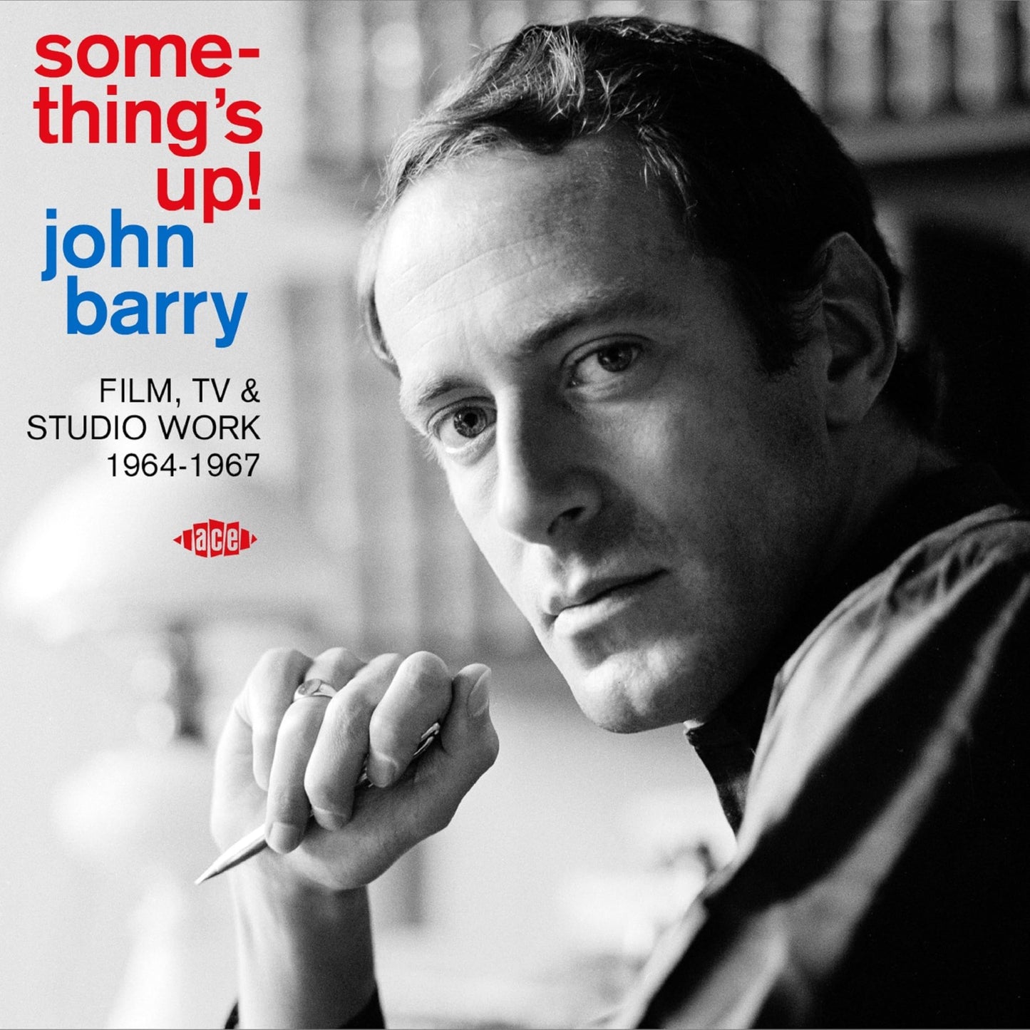 Black and white portrait of John Barry holding a pen with album text overlay.