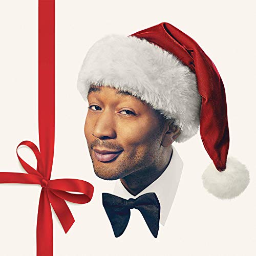 John Legend wearing a Santa hat and black bow tie, smiling.
