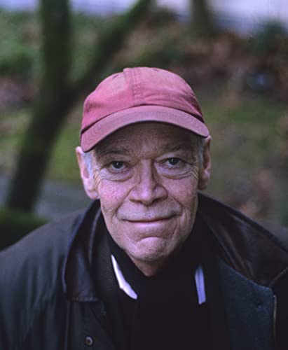 Portrait of an older man wearing a red cap, looking at the viewer.