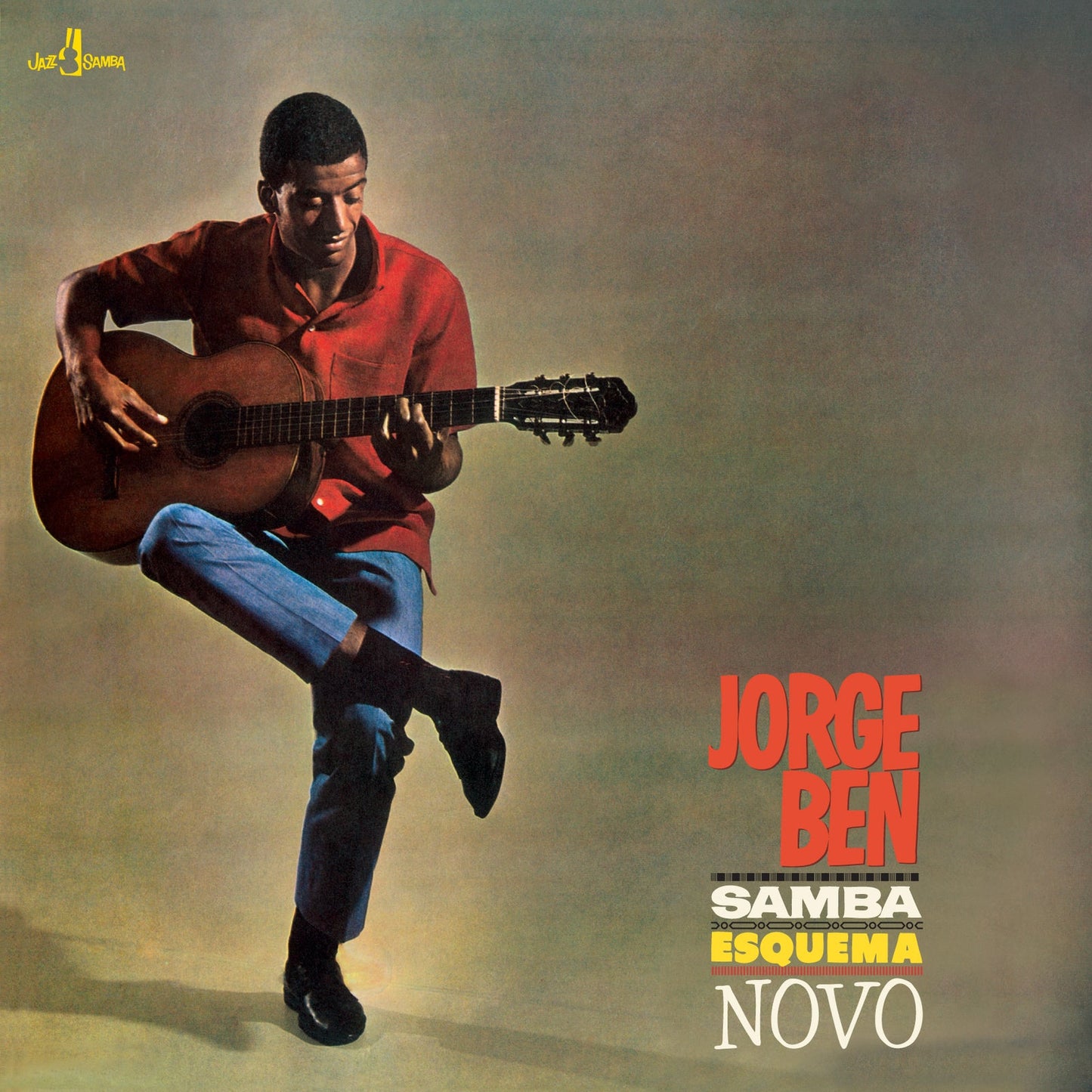 Jorge Ben playing acoustic guitar while standing on one leg against a grey background.