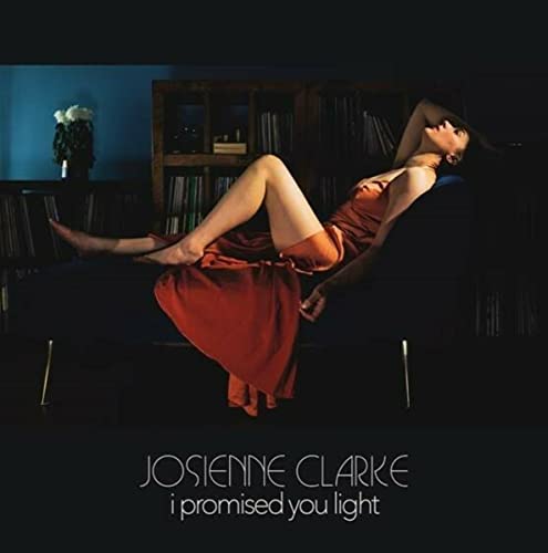 Album cover: woman in red dress reclining in a dark room.