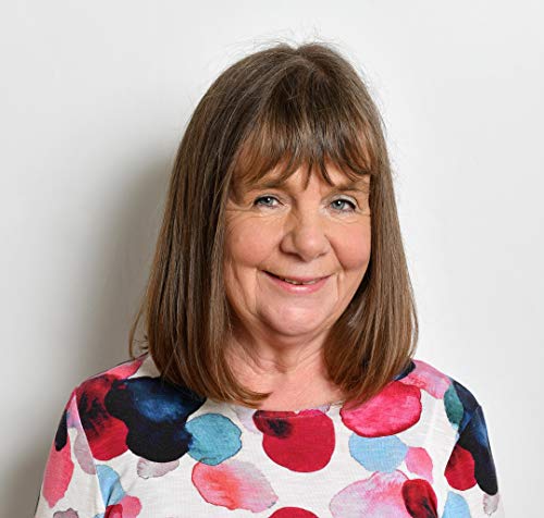Headshot of author Tracey Corderoy, smiling, with brown hair and floral shirt.