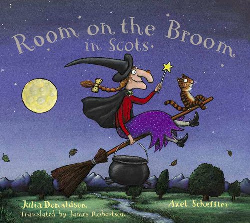 A witch and cat fly on a broomstick over a landscape at night.