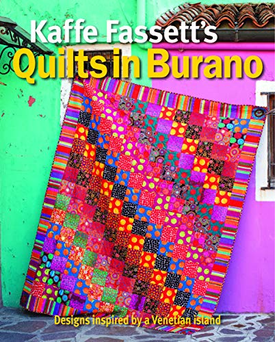 Colorful patchwork quilt displayed against a bright green wall.