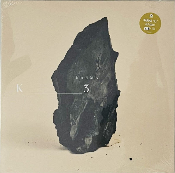 Vinyl record cover featuring a dark, jagged stone shape on a beige background.