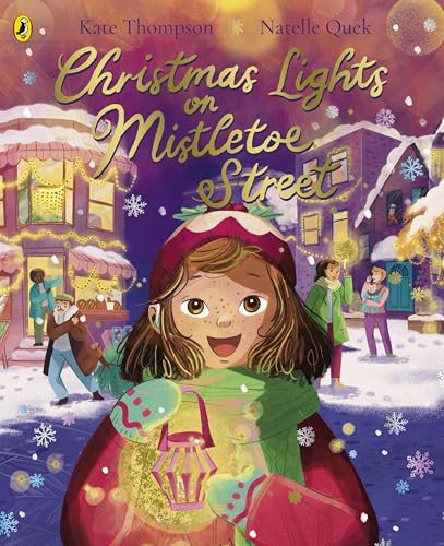 A girl holds a glowing lantern on a snowy street decorated with Christmas lights.