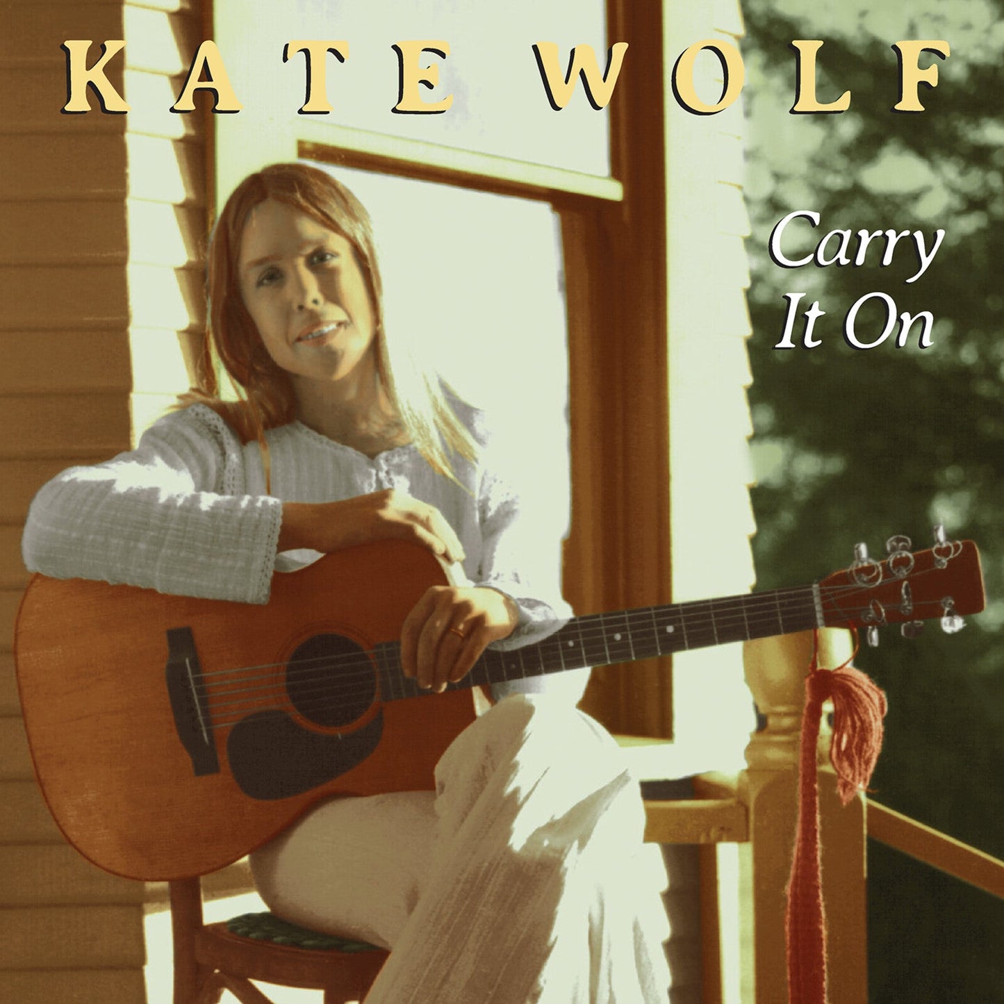 Kate Wolf album cover: woman with guitar, rustic porch background.