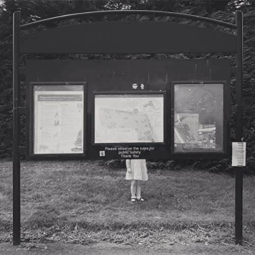 Black and white album cover featuring a child standing before a sign.