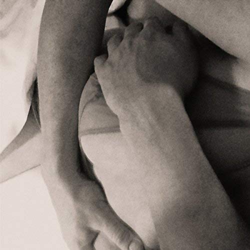 Black and white close-up of arms embracing a person’s torso.