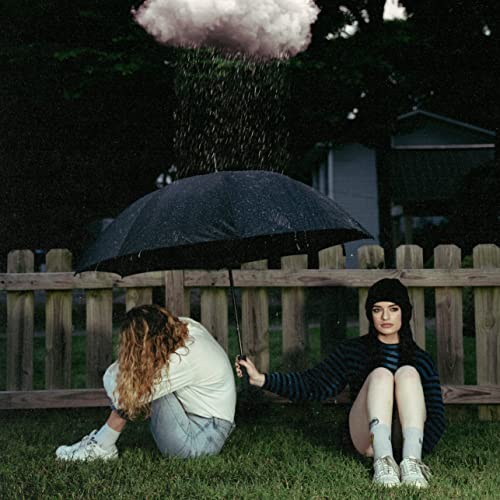 Woman with umbrella sits in rain under a stormy, pink-tinged sky.