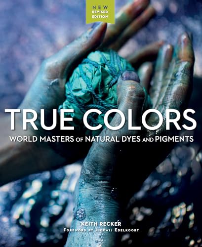 Two hands stained with blue dye hold a bundle of teal fabric in water.