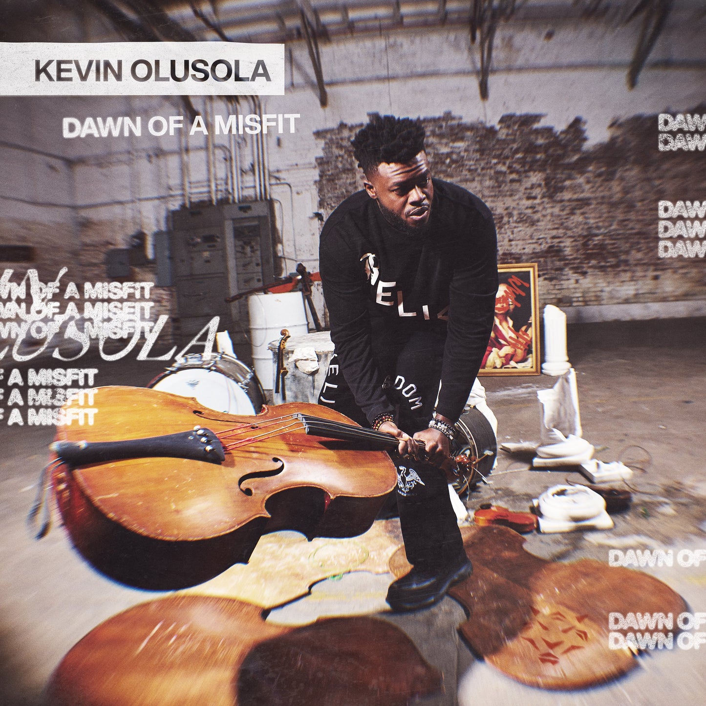 Kevin Olusola poses with a cello in a textured, industrial setting.