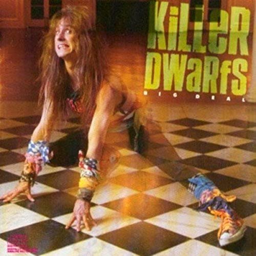 Woman crawling on black and white tiled floor wearing colorful bracelets and sneakers.