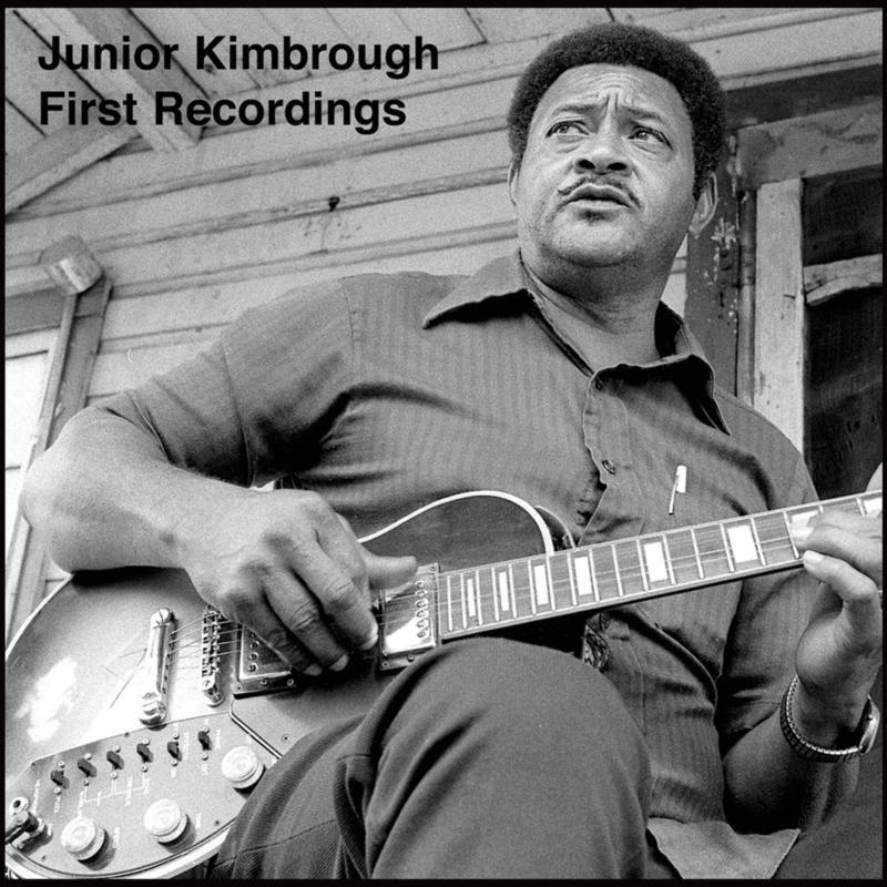 Junior Kimbrough playing guitar, black and white portrait for vinyl album.
