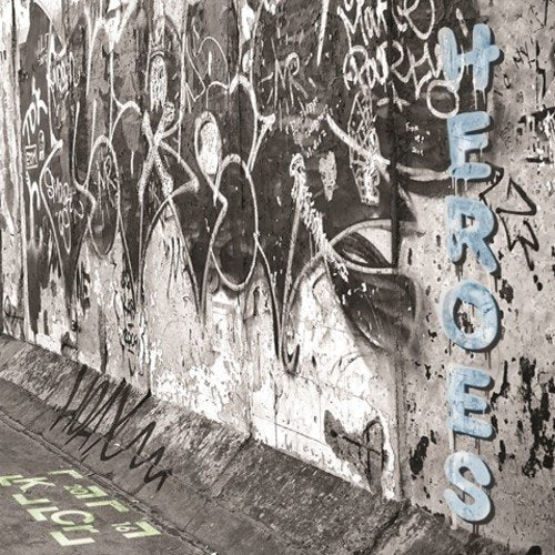 Graffiti-covered wall with "HEROES" in blue vertical letters on the right side.