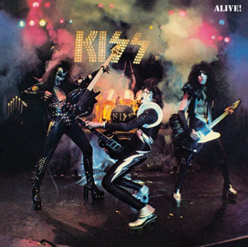 Kiss band members in stage makeup performing with instruments.