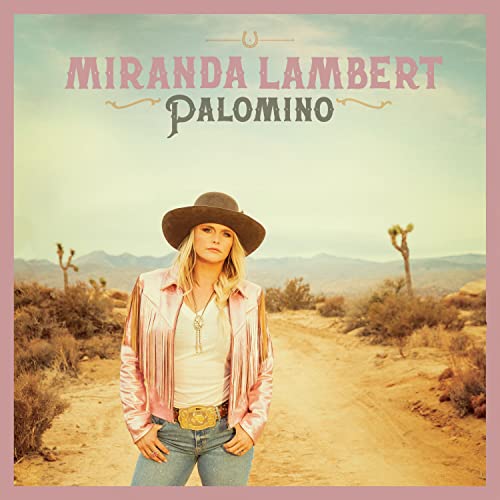 Miranda Lambert wearing a hat and pink fringe jacket in a desert landscape.