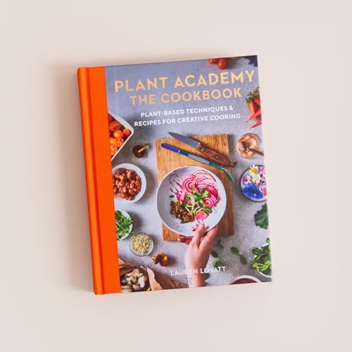 Cookbook cover with plant-based food imagery and orange spine.