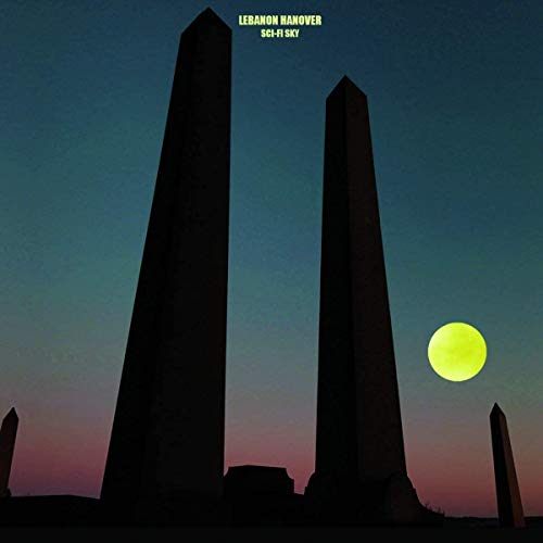 Dark obelisks and a yellow moon against a gradient blue sky.