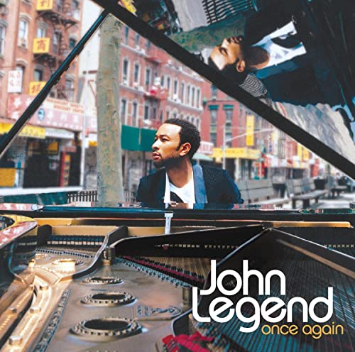 John Legend album cover, featuring him at a grand piano in a city.