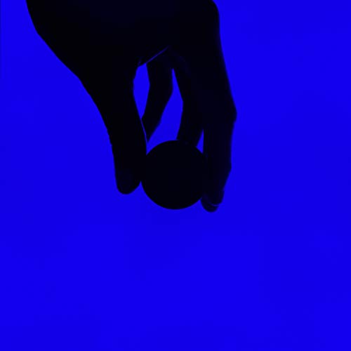 A hand holds a vinyl record against a blue background.