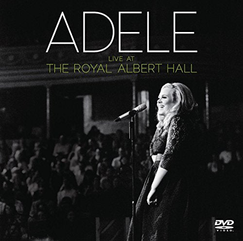 Adele singing into a microphone on stage at Royal Albert Hall.