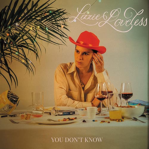 Lizzie Loveless wearing a red cowboy hat at a table with drinks and snacks.