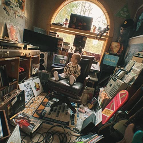 Logic’s “Vinyl Days” CD case sits amongst music equipment and records.