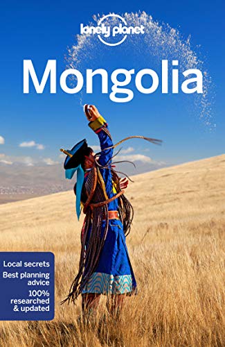 A person in traditional Mongolian clothing tosses grain into the air against a blue sky.