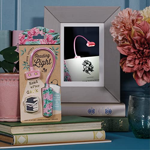 Floral patterned flexible reading light in packaging, standing on books next to a frame.