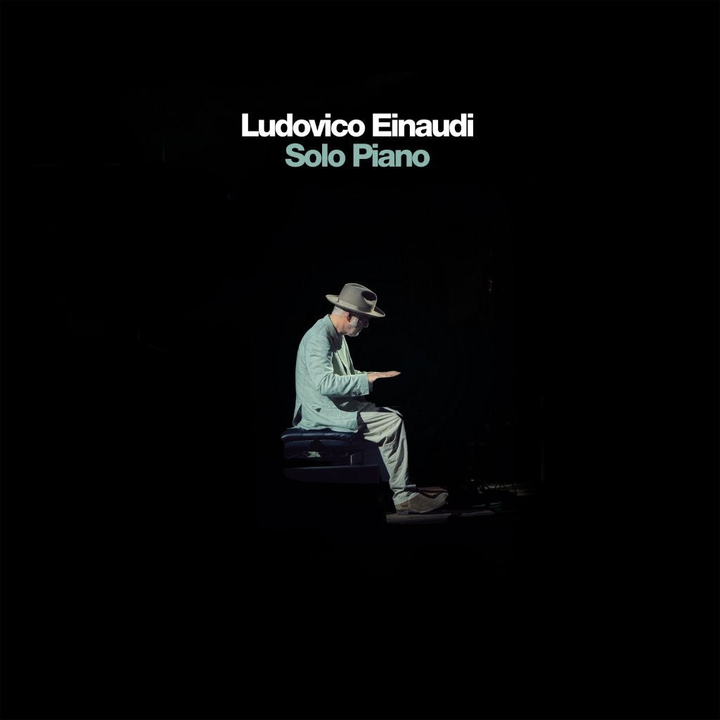 Ludovico Einaudi album cover: man playing piano in darkness.