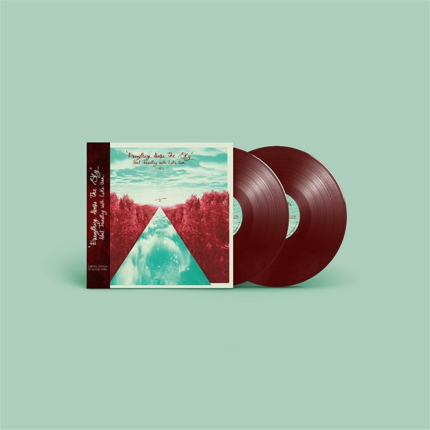 Two oxblood vinyl records with landscape cover art, stacked on pale green.