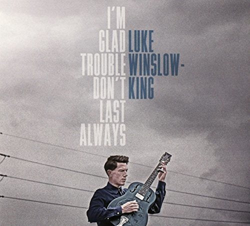 "Album cover with a man playing guitar, cloudy background, and artist's name."