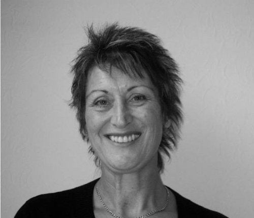 Black and white portrait of a smiling woman with short, spiky hair.