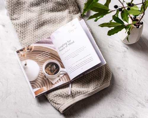 Open devotional book with a mug of tea, resting on a textured blanket.
