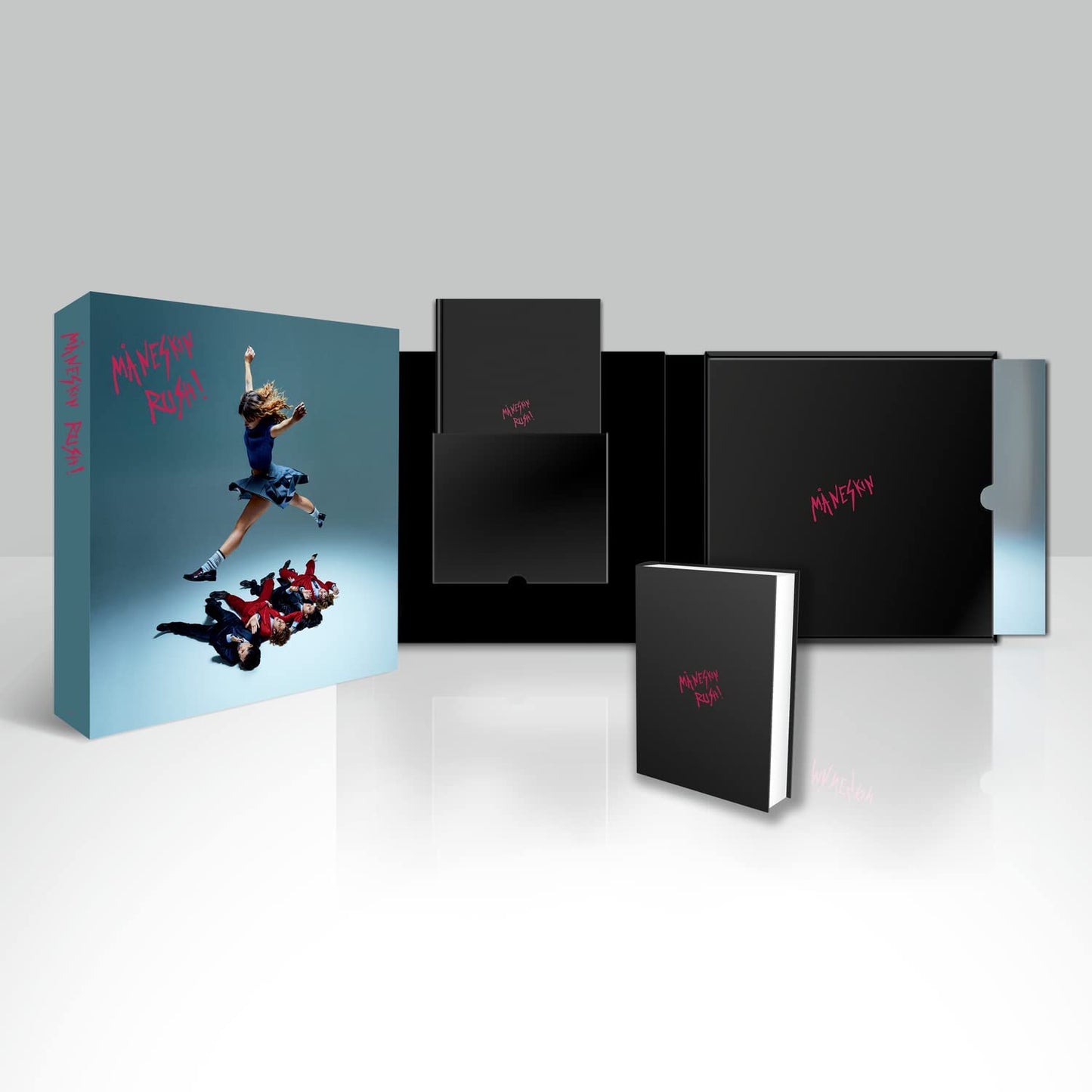 "Blue box with band members on cover, containing black boxes and a small book."