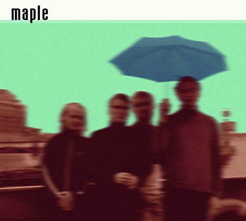 A blurred photo of four people under a blue umbrella against a green sky.