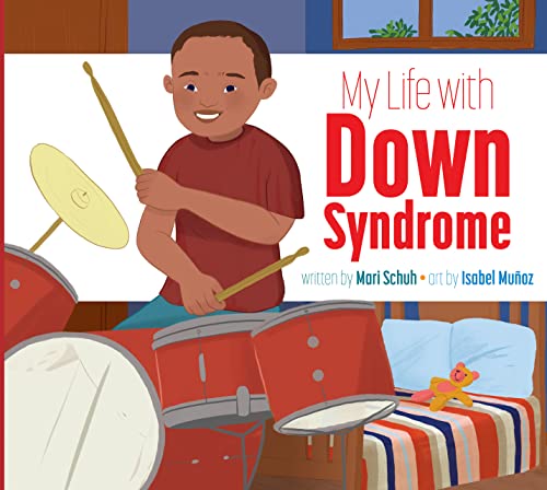 A young boy with Down syndrome playing drums in a bedroom with a teddy bear.