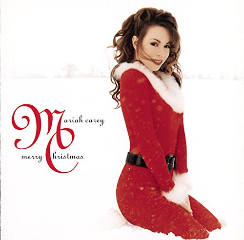 Mariah Carey in red suit kneeling in a snowy landscape.