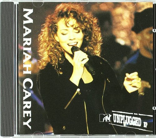 Mariah Carey singing into a microphone on CD cover art.