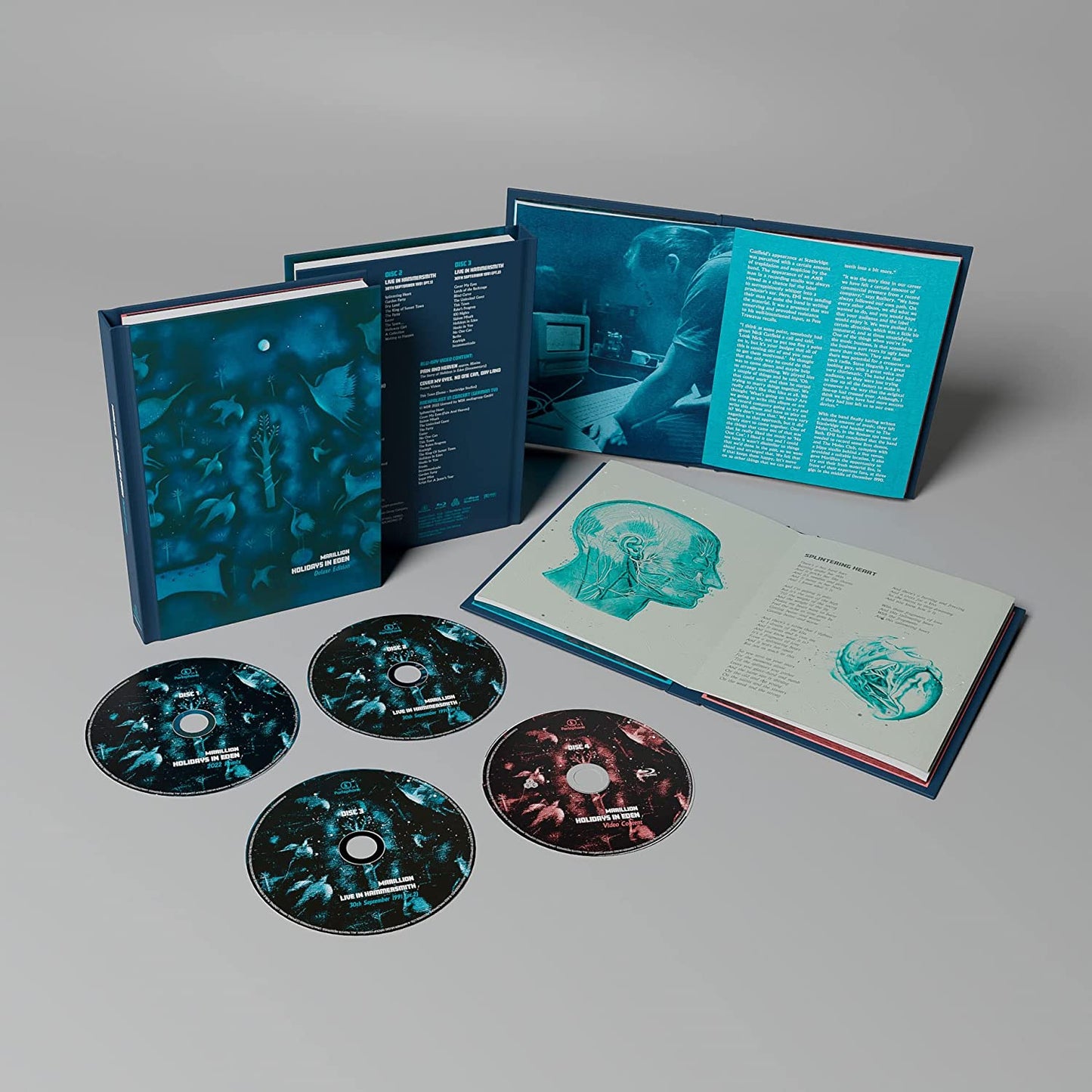 "Holidays In Eden" Blu-ray box set with discs and open booklet on gray background.