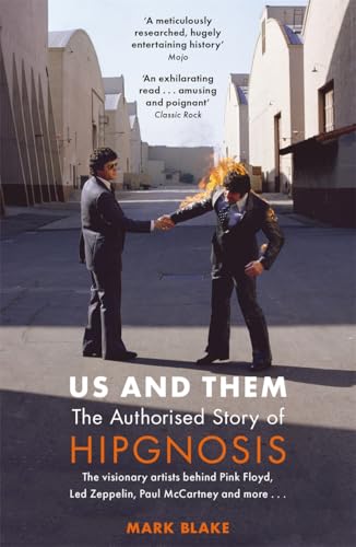 Book cover: two men in suits, one on fire, with title “Us and Them”.