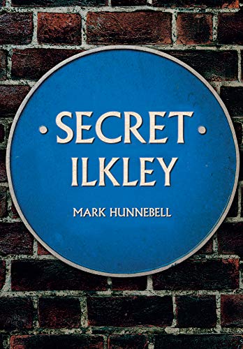 Blue plaque reading "Secret Ilkley" by Mark Hunnebell against brick wall.