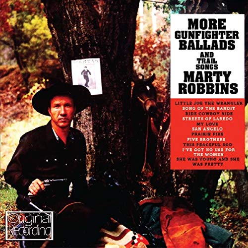 Marty Robbins in a cowboy hat sitting by a tree with a horse nearby.