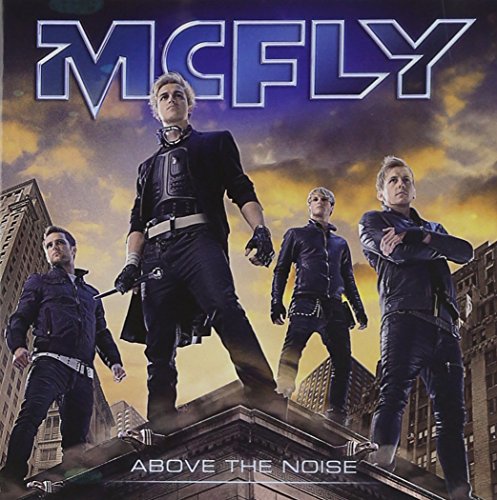 Mcfly band members in dark clothing pose on a city rooftop.